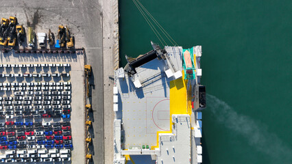 Aerial drone top down photo of new cars lined up in automobile Ro Ro port terminal for import and export