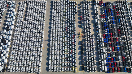 Aerial drone top down photo of new cars lined up in automobile Ro Ro port terminal for import and...