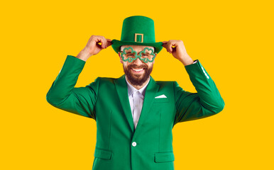 Cheerful man going to party on St Patrick's Day. Happy smiling joyful positive young guy wearing...