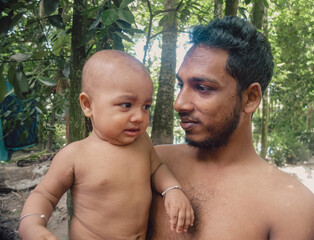 South asian little kid enjoying with his uncle , young boy holding his nephew in arm 