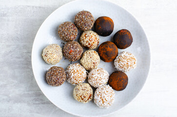 Assorted vegan sweets, Delicious Candy Balls with seeds, dried fruit and cocoa powder, Healthy Candies on a Plate