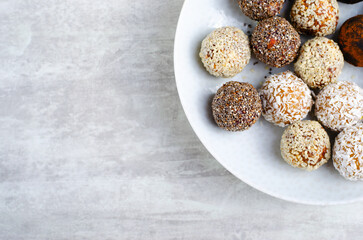 Assorted vegan sweets, Delicious Candy Balls with seeds, dried fruit and cocoa powder, Healthy Candies on a Plate