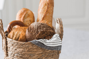 Assortment of fresh bread in a wicker basket close-up. Freshly baked bread on the table. The...