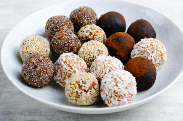 Assorted vegan sweets, Delicious Candy Balls with seeds, dried fruit and cocoa powder, Healthy Candies on a Plate