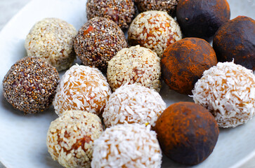Assorted vegan sweets, Delicious Candy Balls with seeds, dried fruit and cocoa powder, Healthy Candies on a Plate