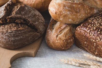 Fresh delicious bread close-up. Freshly baked sourdough bread with a golden crust on a wooden board. The context of a bakery with delicious bread. Confectionery products.
