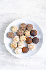 Assorted vegan sweets, Delicious Candy Balls with seeds, dried fruit and cocoa powder, Healthy Candies on a Plate