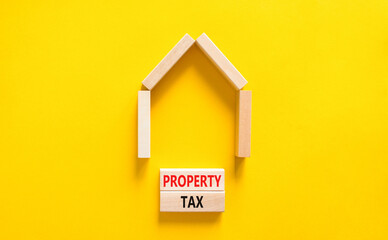 Fototapeta na wymiar Property tax symbol. Concept words Property tax on wooden blocks. Beautiful yellow table yellow background. House model from wooden blocks. Business and property tax concept. Copy space.