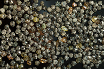 Rough technical industrial quality diamonds on black background. High quality photo