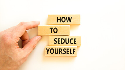 How to seduce yourself symbol. Concept word How to seduce yourself on wooden blocks. Businessman hand. Beautiful white table white background. Business and how to seduce yourself concept. Copy space.