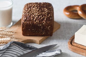 Fresh delicious whole grain rye bread with seeds close-up. Freshly baked bread on a wooden board. The context of a bakery with delicious bread. Confectionery products.