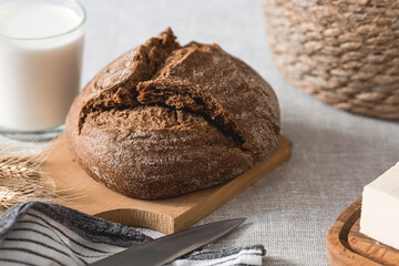 Fresh delicious bread close-up. Freshly baked sourdough bread with a golden crust on a wooden board. The context of a bakery with delicious bread. Confectionery products.