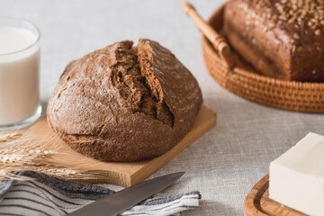 Fresh delicious bread close-up. Freshly baked sourdough bread with a golden crust on a wooden board. The context of a bakery with delicious bread. Confectionery products.