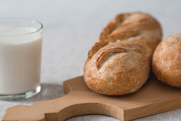 Fresh delicious bread close-up. Freshly baked sourdough bread with a golden crust on a wooden board. The context of a bakery with delicious bread. Confectionery products.