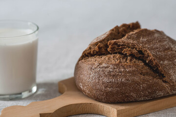 Fresh delicious bread close-up. Freshly baked sourdough bread with a golden crust on a wooden board. The context of a bakery with delicious bread. Confectionery products.