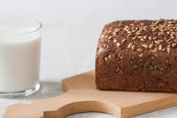 Fresh delicious whole grain rye bread with seeds close-up. Freshly baked bread on a wooden board. The context of a bakery with delicious bread. Confectionery products.