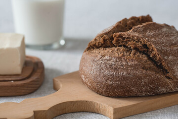Fresh delicious bread close-up. Freshly baked sourdough bread with a golden crust on a wooden board. The context of a bakery with delicious bread. Confectionery products.