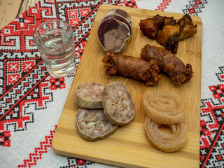 romanian christmas assorted starters on wooden plateau with glass of plum brandy known as tuica aside 