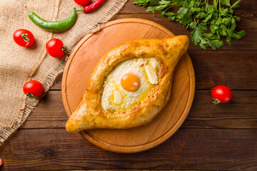 ajara Khachapuri with cheese, egg and butter, georgian kitchen on wooden table top view
