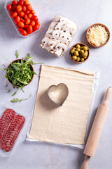 Making of mini pizzas in a heart shape for Valentines day holiday.