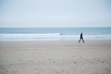 Fototapeta na wymiar un homme marche sur la plage