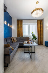 A modern living room interior of a luxurious hotel apartment with a designer couch, and art decorations. Real photo.