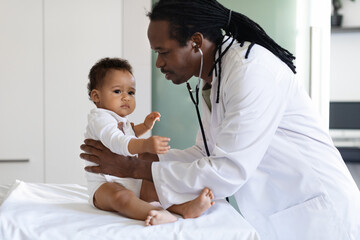 Baby Check Up. Black Pediatrician Doctor Examining Little Infant Boy In Clinic