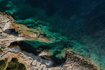 Seascape and sandy beach with turquoise clear waters and trees in Greece