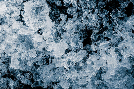 Crushed ice pieces on black background. Chill backdrop.