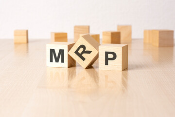 MRP - an abbreviation of wooden blocks with letters on a gray background. reflection caption on the mirrored surface of the table. selective focus