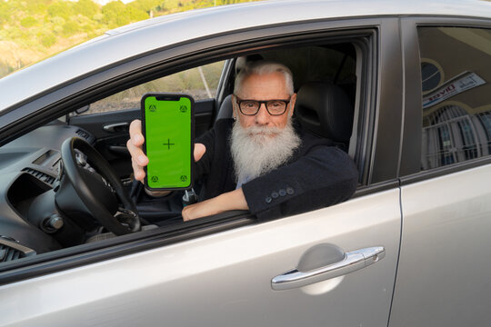 Senior Man In Car Showing Phone With Green Screen