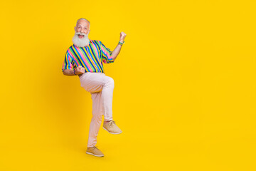 Full length photo of funky cool man wear colorful shirt rising fists empty space isolated yellow color background