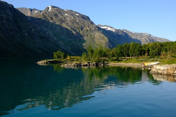 Fototapeta na wymiar Beautiful surroundings of a mountain hut on Lake Gjende in Norway, below the world-famous Besseggen mountain ridge.