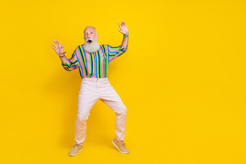 Fototapeta na wymiar Full length photo of charming impressed man wear colorful shirt enjoying discotheque empty space isolated yellow color background