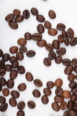 Coffee beans are scattered on a white table. photo of freshly roasted coffee close-up of high quality. top view