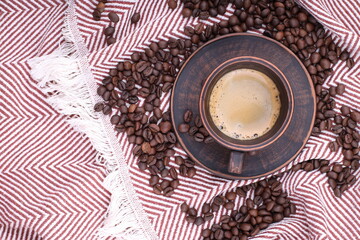 Coffee beans are scattered on the fabric. a close-up photo of freshly roasted coffee of high quality. top view