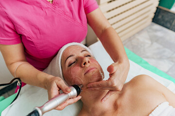 Close-up of woman getting facial hydro peeling treatment at cosmetic beauty spa clinic.