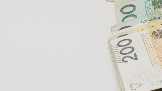 Polish money Zloty. Recalculation of money paper bills one hundred two hundred zloty. Isolated. Official Polish currency banknotes fall on the table on a white background. Close-up. Place for text