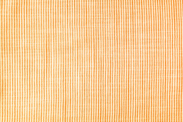 Natural linen texture as background. Cotton fabric with orange and white line striped pattern, texture close up, top vies, flat lay. Backdrop, wallpaper. Matereal for clothes, curtain and upholstery