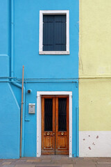 Fototapeta na wymiar Retro entrance door and window on blue facade