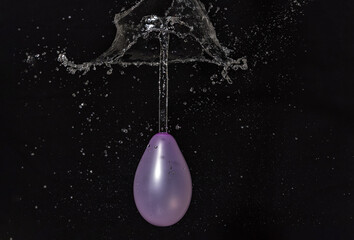 Obraz na płótnie Canvas water balloon burst, black background
