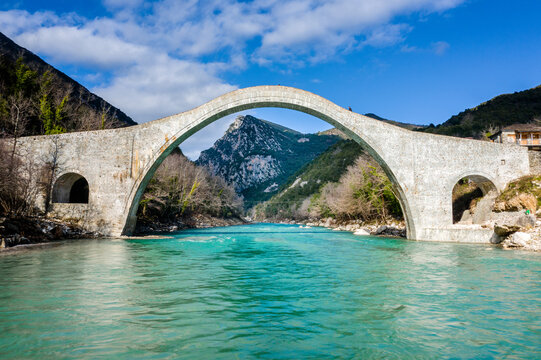 The great arched stone bridge of Plaka on Arachthos river, Tzoumerka, Greece. - Powered by Adobe