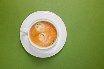 Cup of fresh espresso on the green background