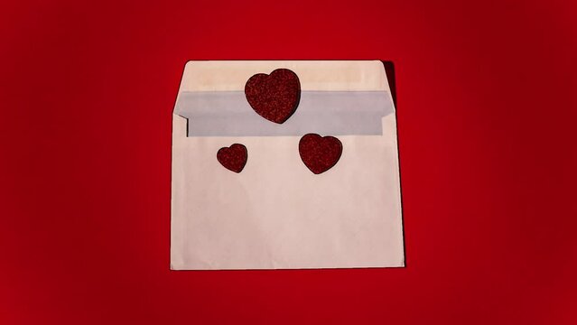 Stop motion pencil scketch Animation of a love letter with red hearts coming out of it, and divided into three parts.. 4K Romantic looped animation on red background for Valentine's day, St