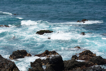 Fototapeta na wymiar Lava stones in the surf