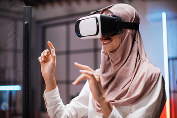 Young female company worker having briefing with modern technology. Muslim business woman in VR...