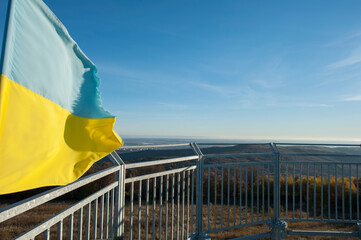 The flag of Ukraine on the observation tower high in the mountains above the Poloniny