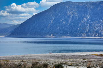 Beach of Salda Lake, in Burdur Turkey.A woman sunbathing on the beach.The lake sedimentary records show high resolution climate changes that are related to solar variability during the last millennium