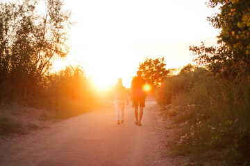 A couple in sunset, walking towards the sun