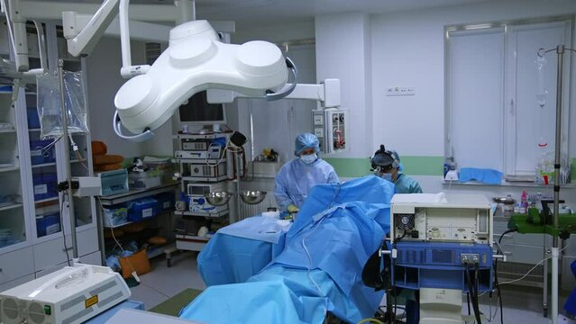 Surgical procedure conducted in the modern operational room. Doctor assisted by a nurse performs surgery.